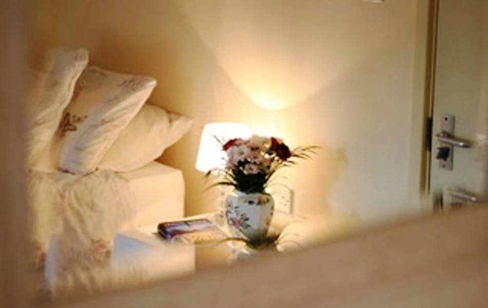 A lit lamp on a bedside table