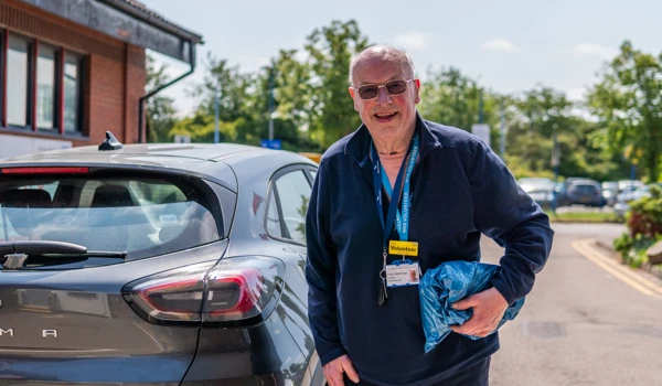 Older Volunteer Man Standing By Car
