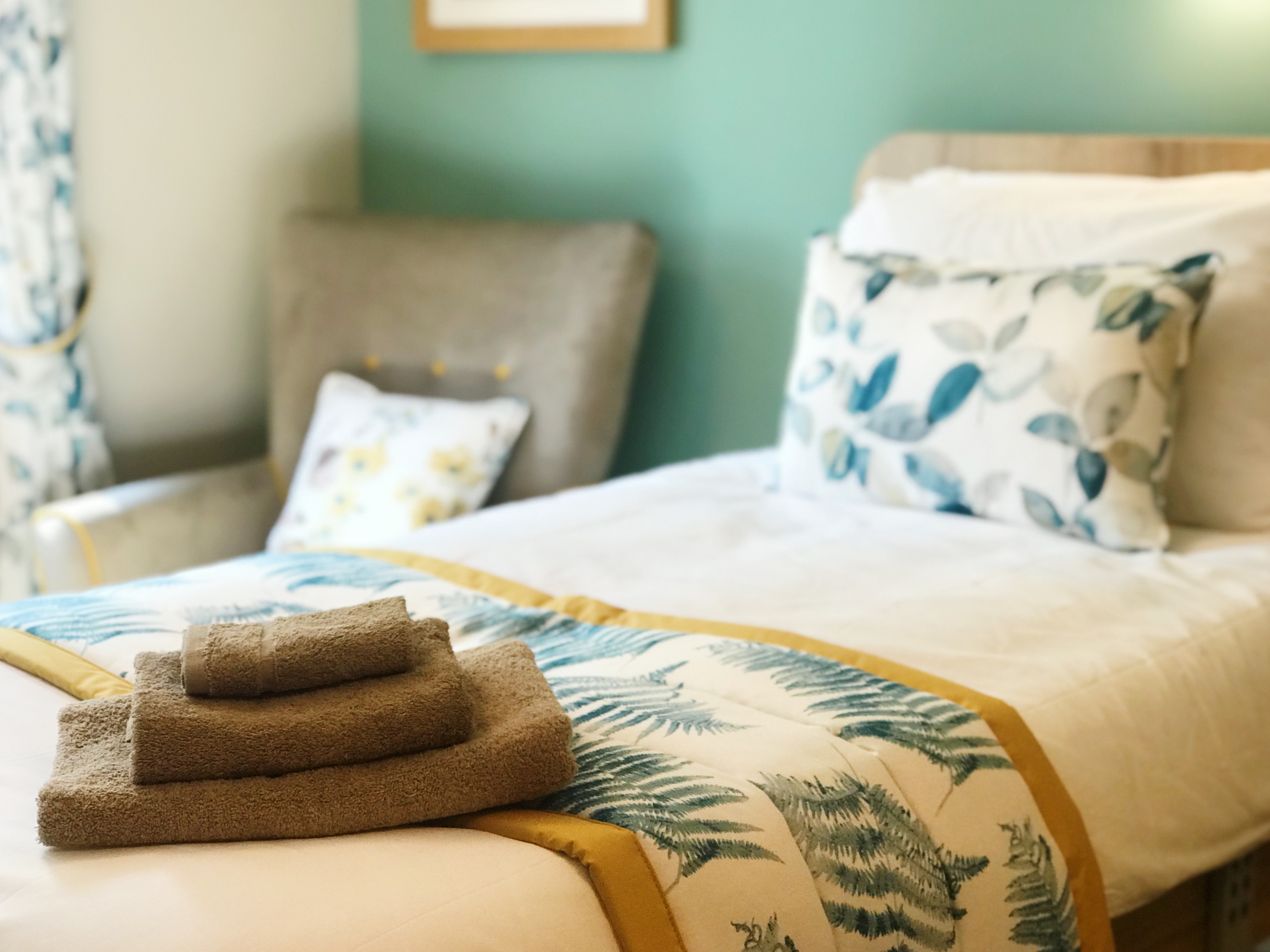 A beautifully styled resident room at Westall House dementia care home in Horsted Keynes with fresh towels and decorative pillows