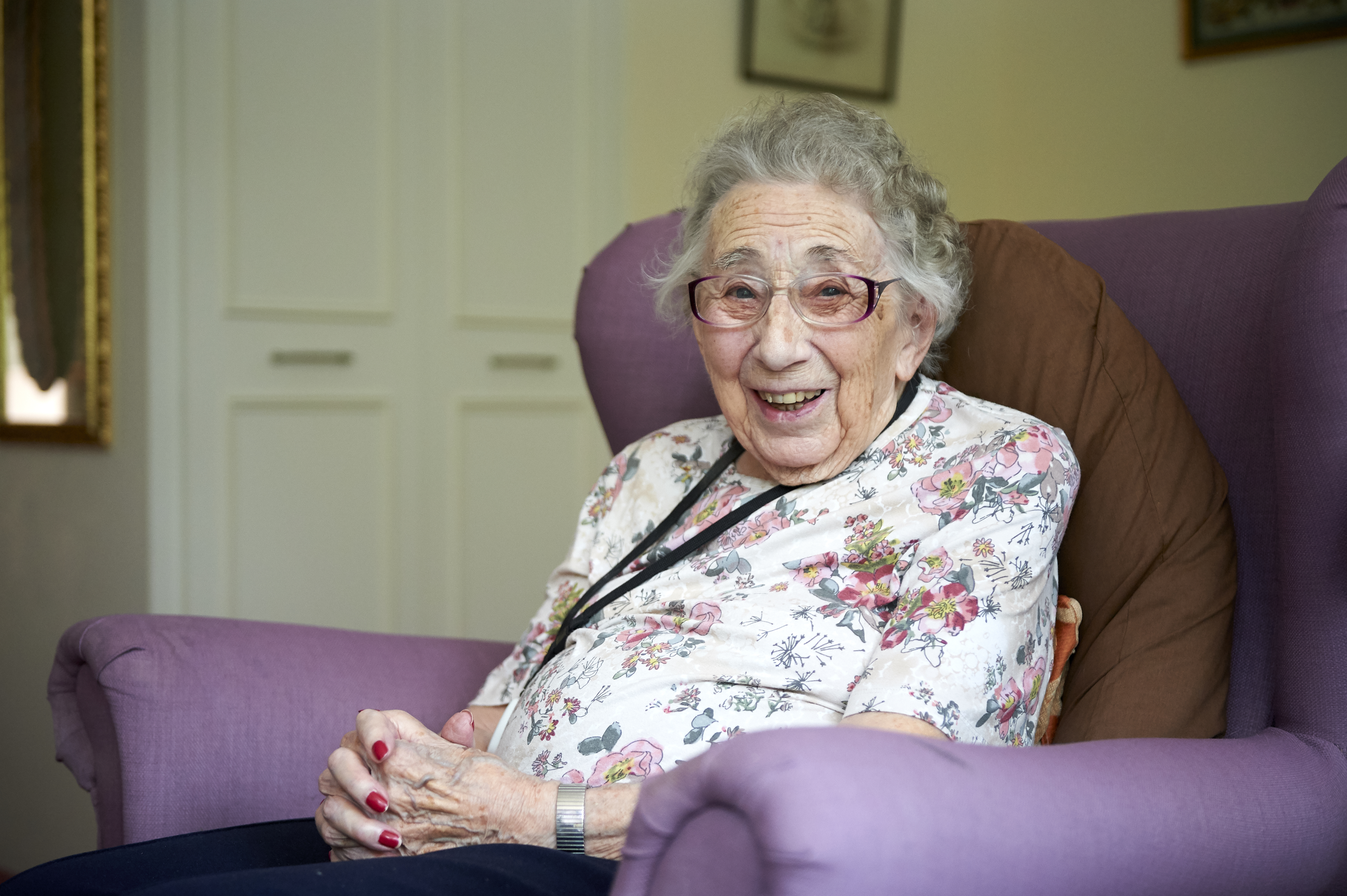 Residents smiling in her room at Westhall House, Horsted Keynes