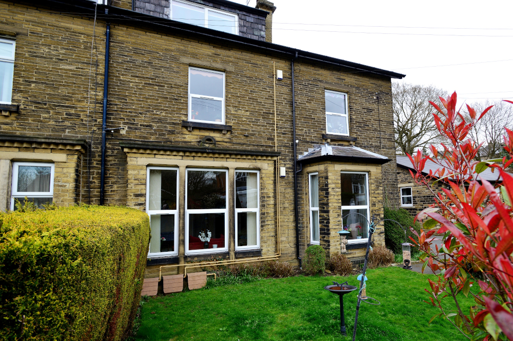A large front window with a bird bath in the garden