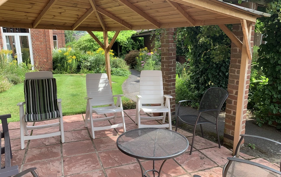 Abbeyfield Firs Complex garden showing wood and brick built gazebo with outdoor seating area