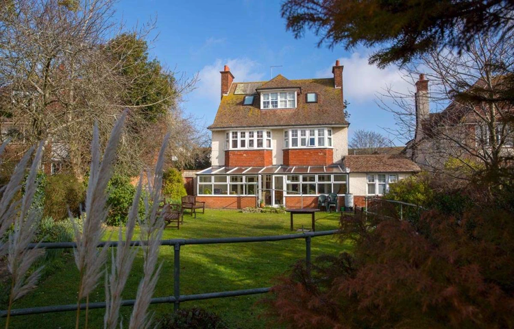 Back exterior of Lade House leading onto large sunny garden where residents can while away the hours in the sun