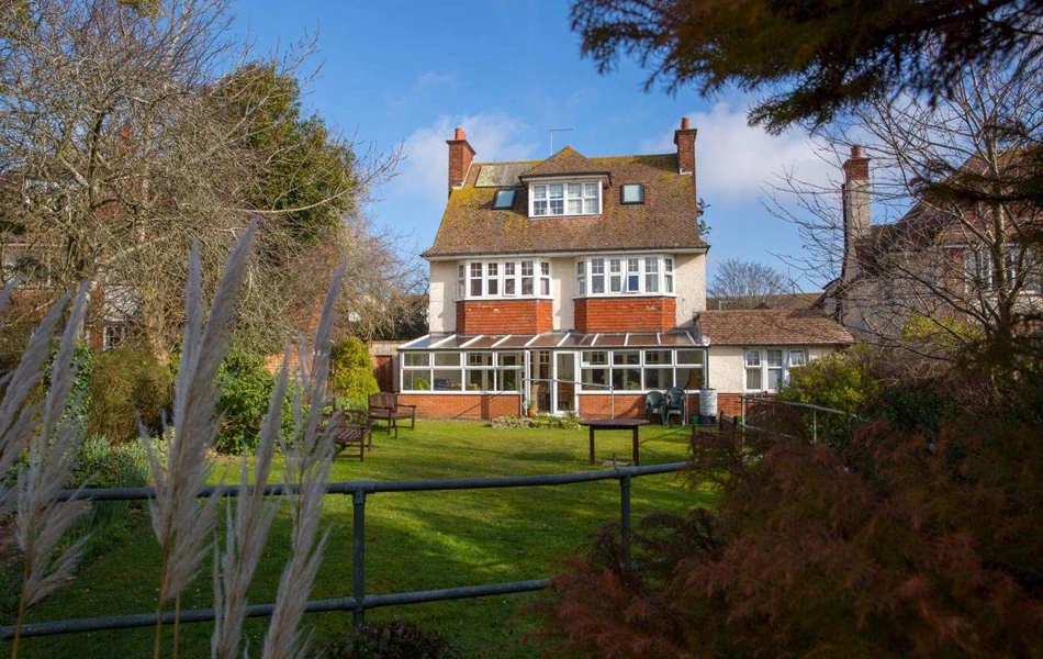 Back exterior of Lade House leading onto large sunny garden where residents can while away the hours in the sun