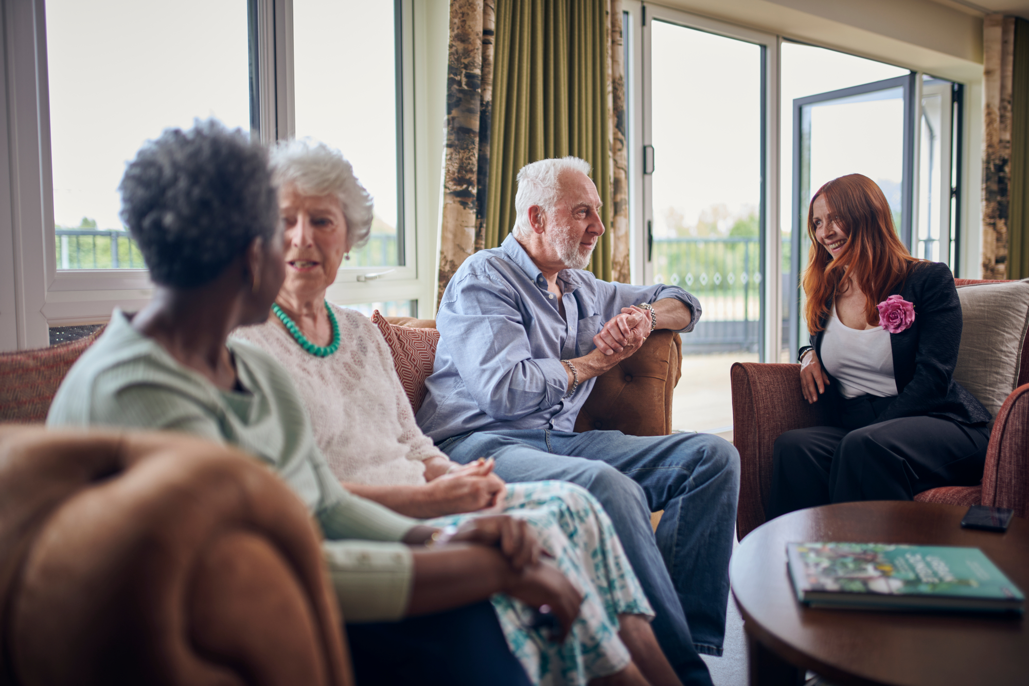 Group Of People Sitting In Communal Lounge Together