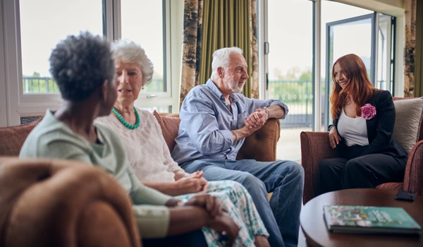 Group Of People Sitting In Communal Lounge Together