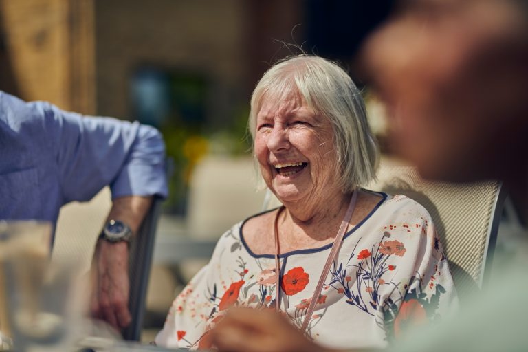 Older Woman Enjoying The Sunshine With Other Residents on Roundhay, GU1 2JH