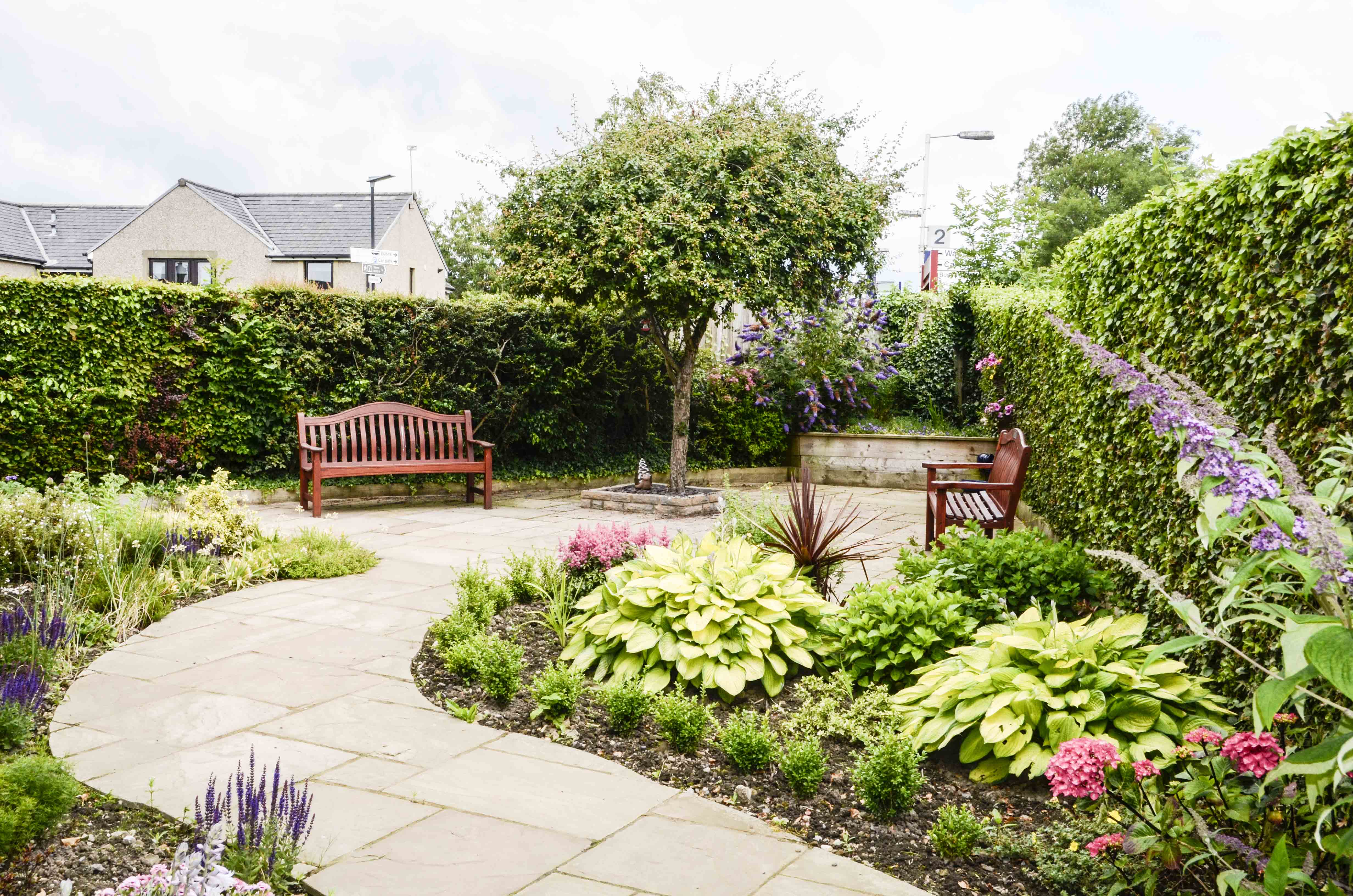 Winding path through the garden with two benches either side at Castle View House, BB7 2DT