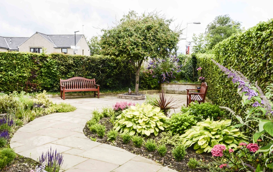 Winding path through the garden with two benches either side at Castle View House, BB7 2DT