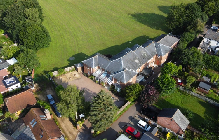 Fields and green spaces surround the house
