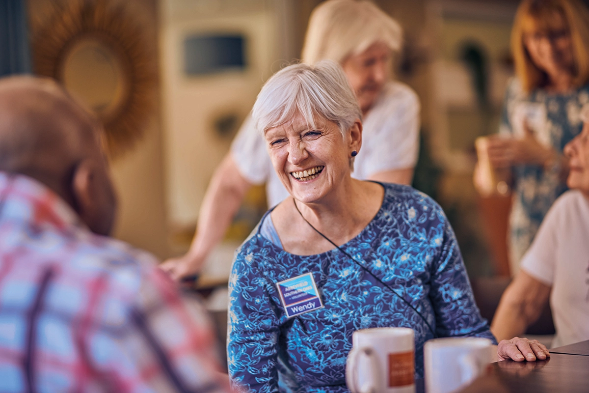Smiling Older Woman Socialising With Others