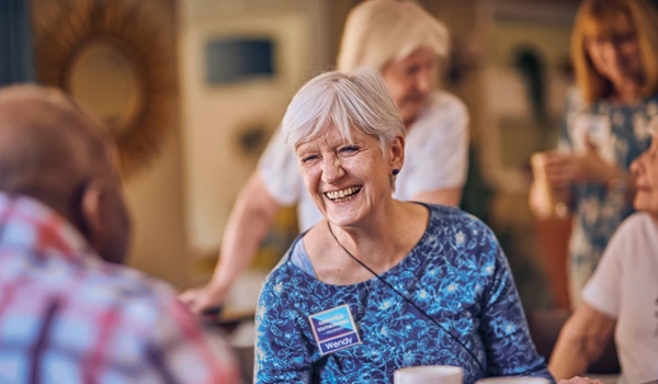 Smiling Older Woman Socialising With Others