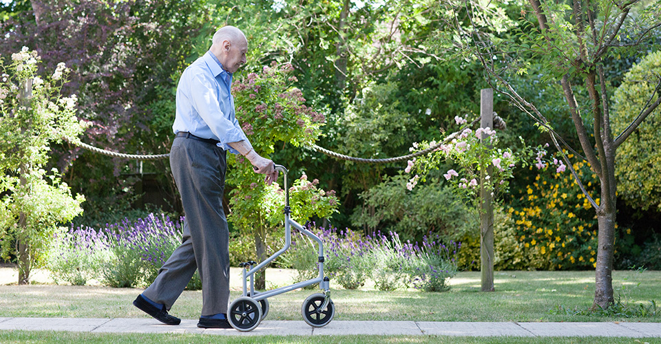 Resident walking around the garden at Roundhay, Guildford GU1 2JH
