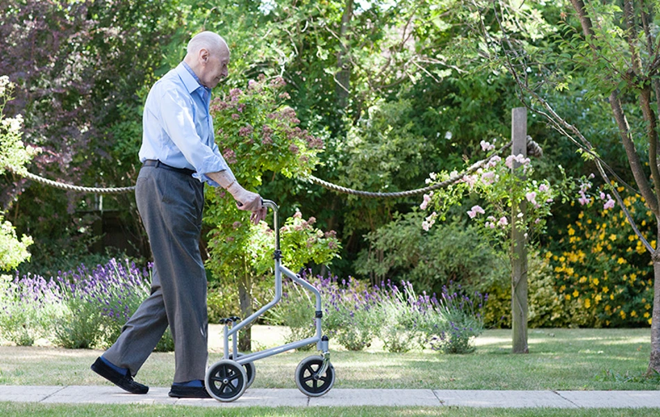Resident walking around the garden at Roundhay, Guildford GU1 2JH