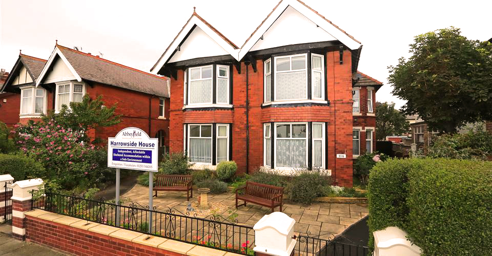 Large red brick house with two benches at the front