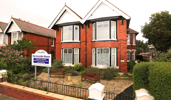 Large red brick house with two benches at the front