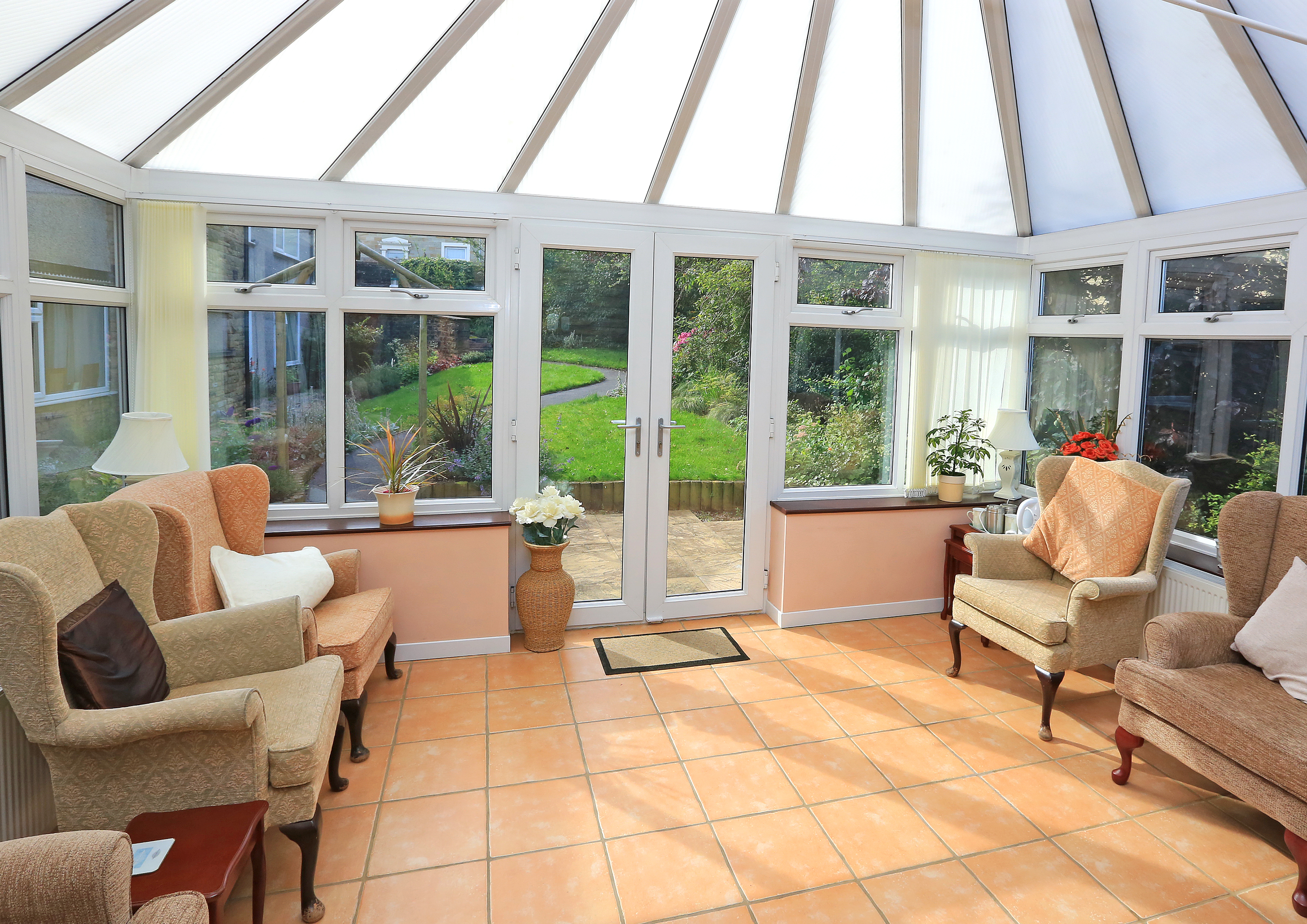 Bright conservatory with ample seating and views of the garden