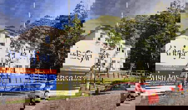 A large white house with a sign to the front