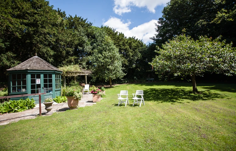 The summer house in the garden with chairs on the grass