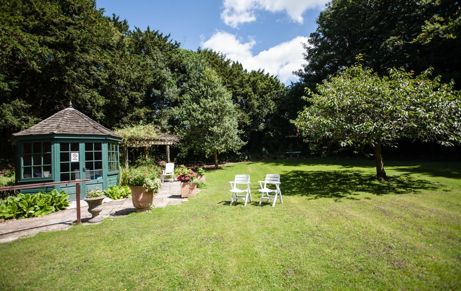 The summer house in the garden with chairs on the grass
