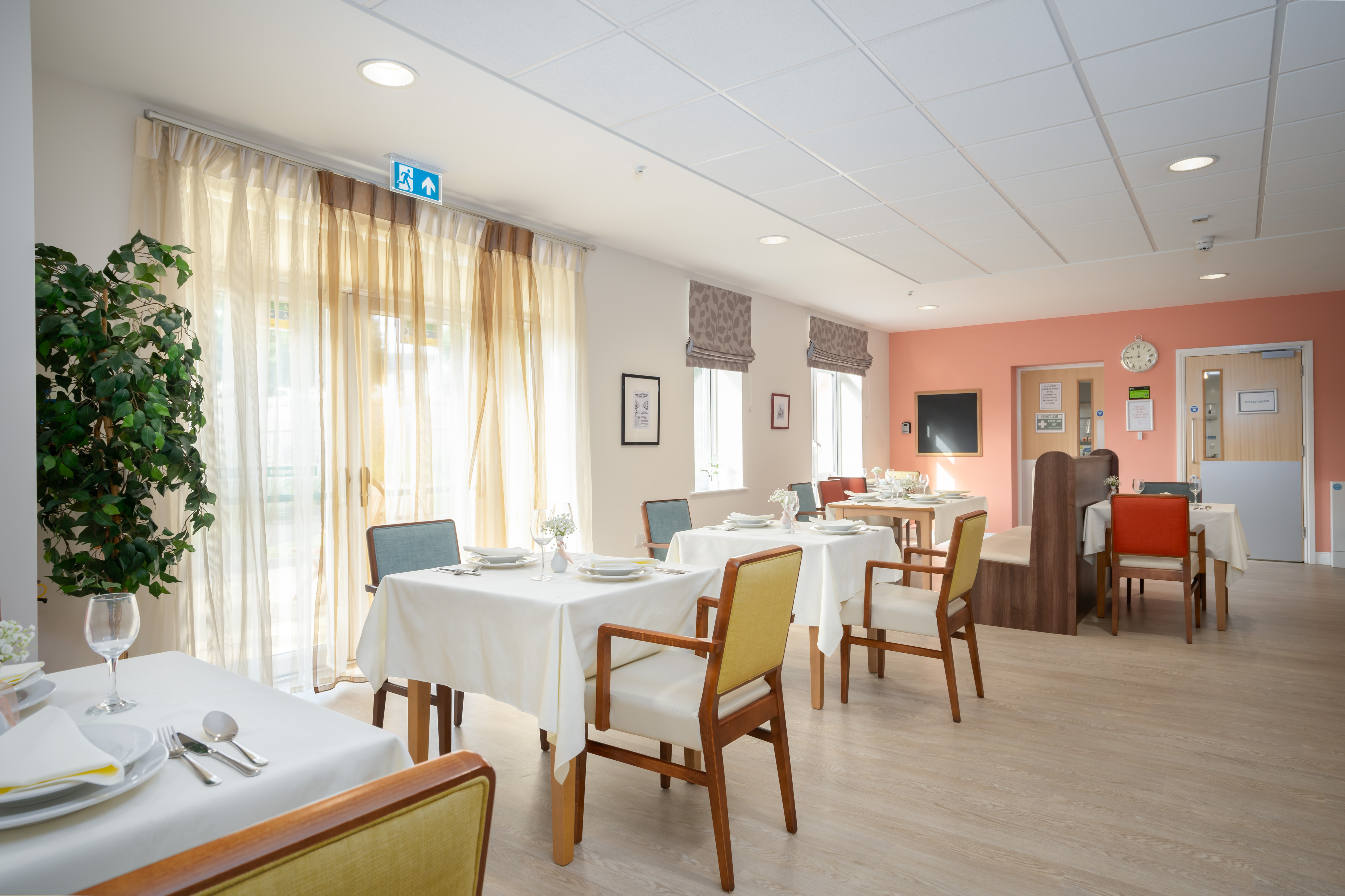 Resident dining room tables by windows at Hope Bank View
