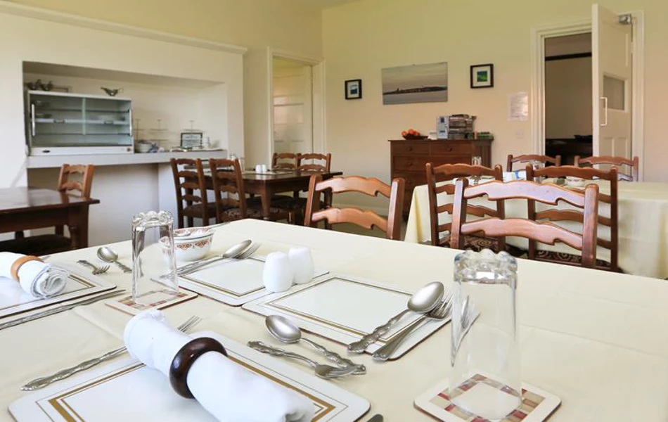 Dining area with tables set for dinner at Armstrong House