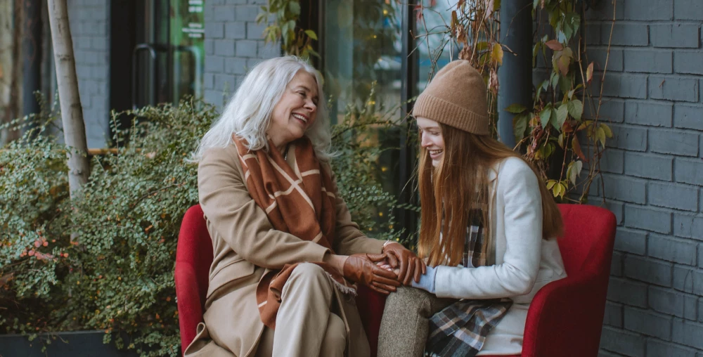 Older Woman And Younger Women Talking Together Outside
