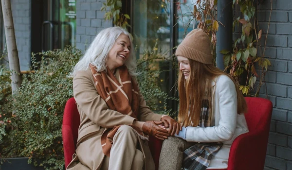 Older Woman And Younger Women Talking Together Outside