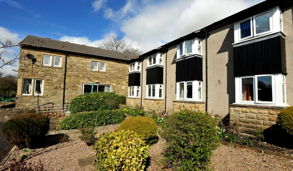 Garden area with shrubs under the house windows outside Abbeyfield House, Settle