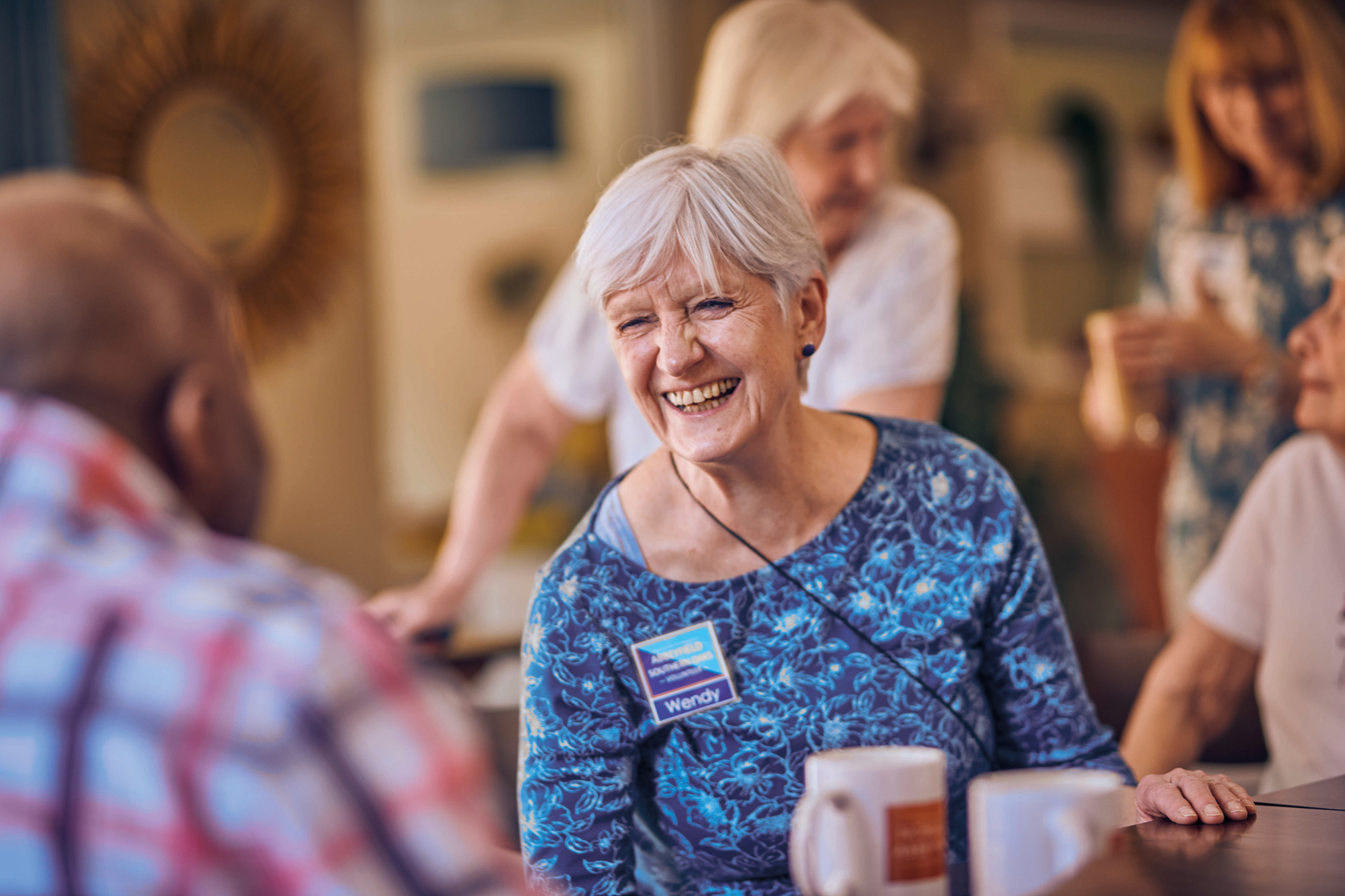 Smiling Older Woman Sitting With A Group Of Other People