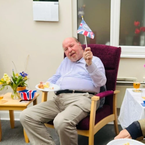 A man sitting down waving a union jack 