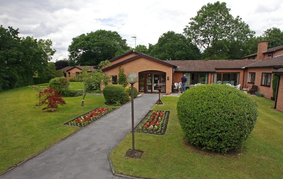 The path leading to the front entrance with tall lamps and flowers in the borders