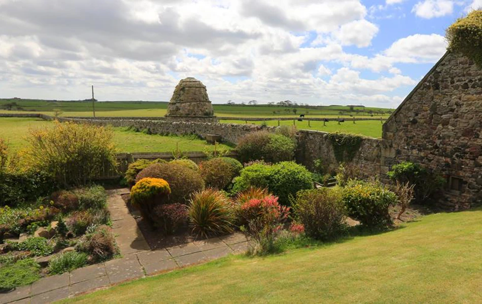 A view of the garden and countryside surrounding Armstrong House, Bamburgh