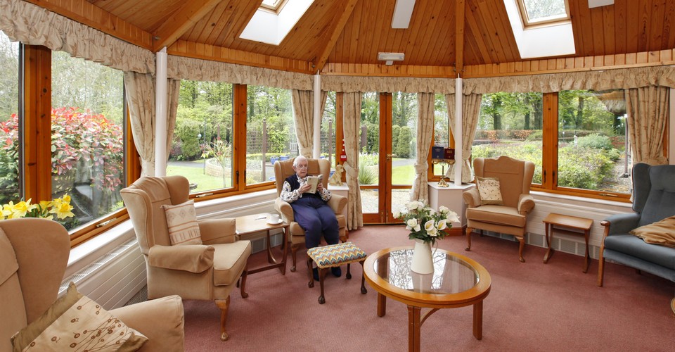 A resident sat reading in the conservatory