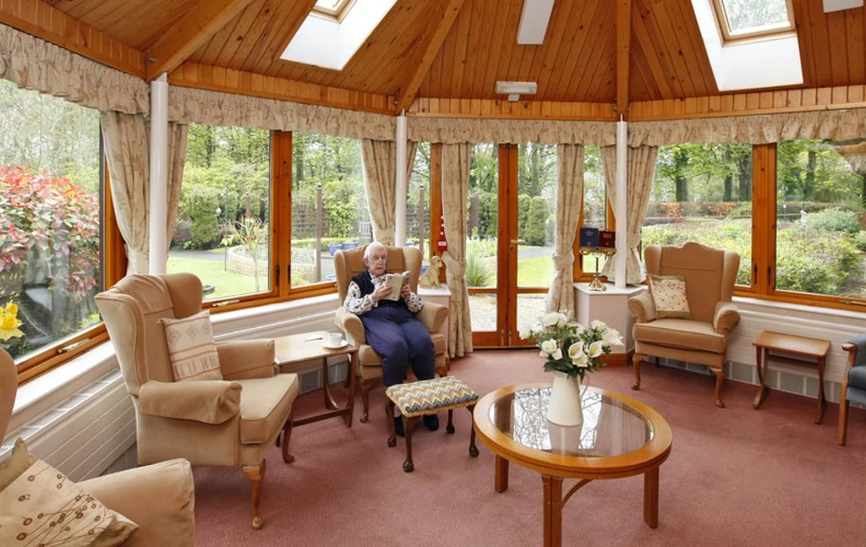 A resident sat reading in the conservatory