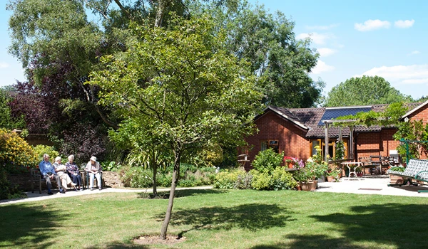 Residents enjoying the sunshine in the large garden sitting on a bench together