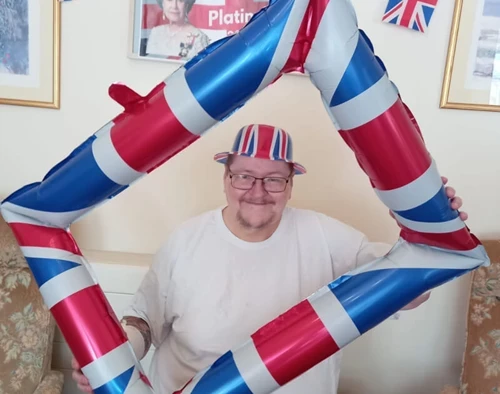 A man posing in an inflatable union jack picture frame