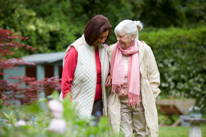 Resident And Staff Member Take A Stroll