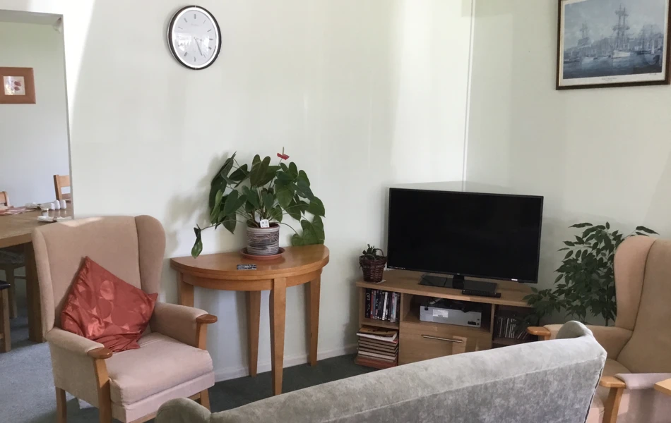 Residents in lounge with sofa and chair in MacPherson House