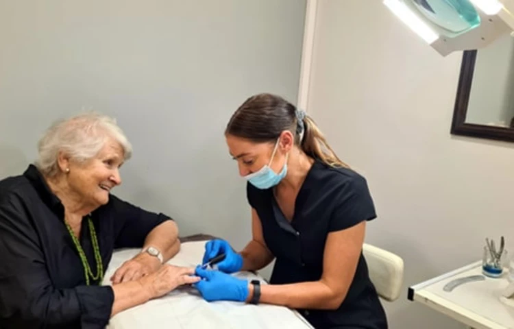 Resident receiving treatment from beautician at Girton Green