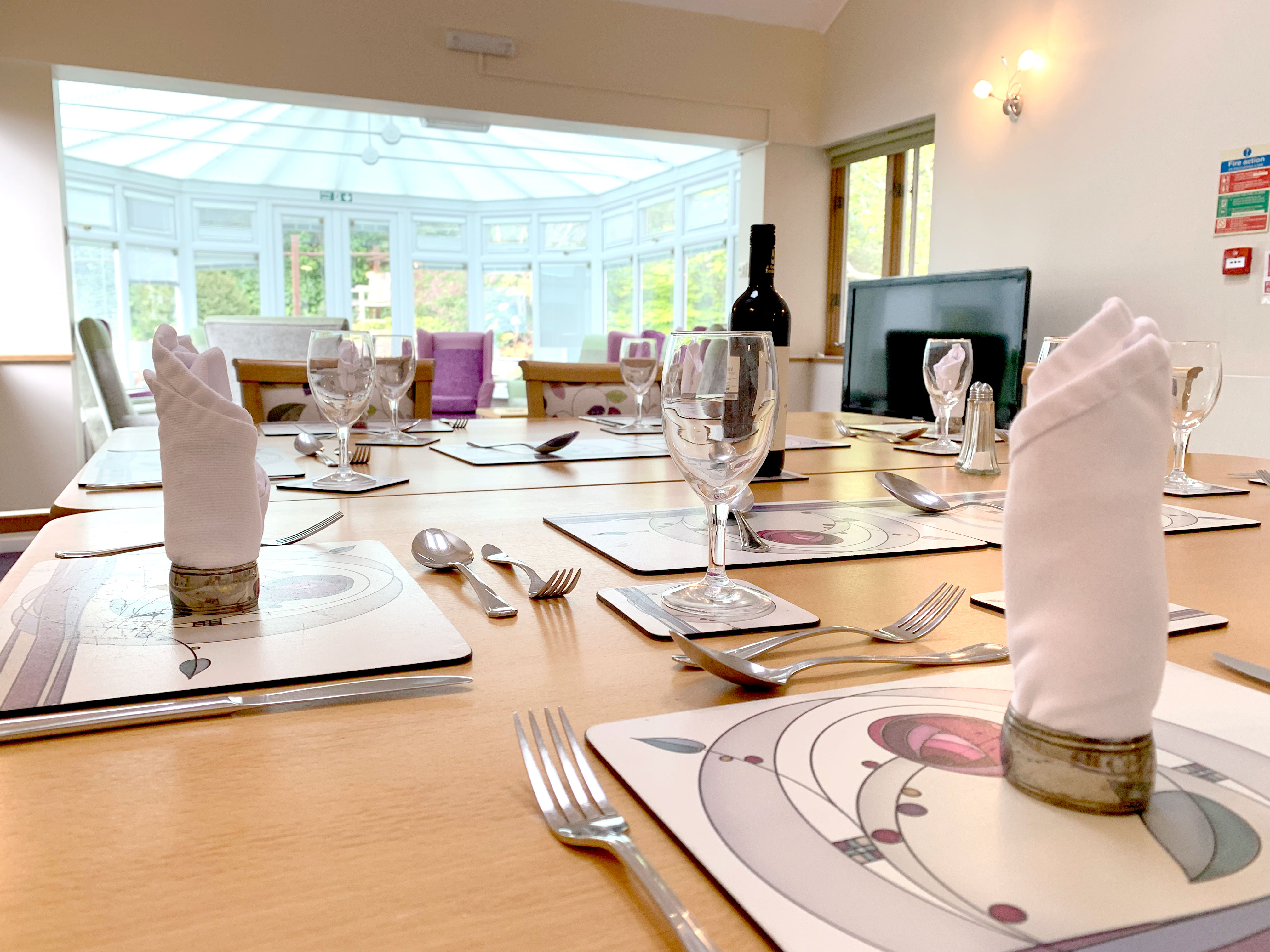 Beautifully set dining room table overlooking the conservatory at Garrad House