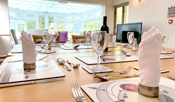 Beautifully set dining room table overlooking the conservatory at Garrad House