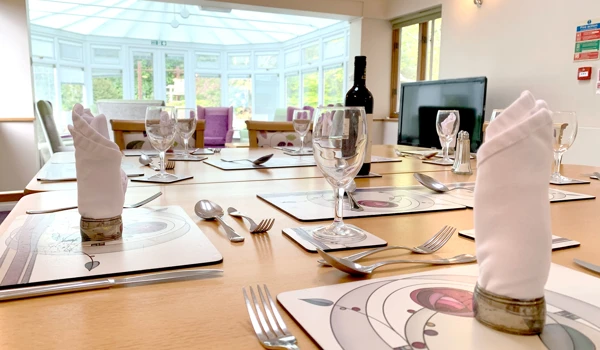 Beautifully set dining room table overlooking the conservatory at Garrad House