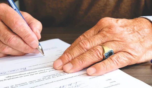 Older Man Signing A Document