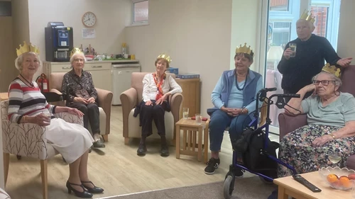 A group of people watching the TV with gold crowns on