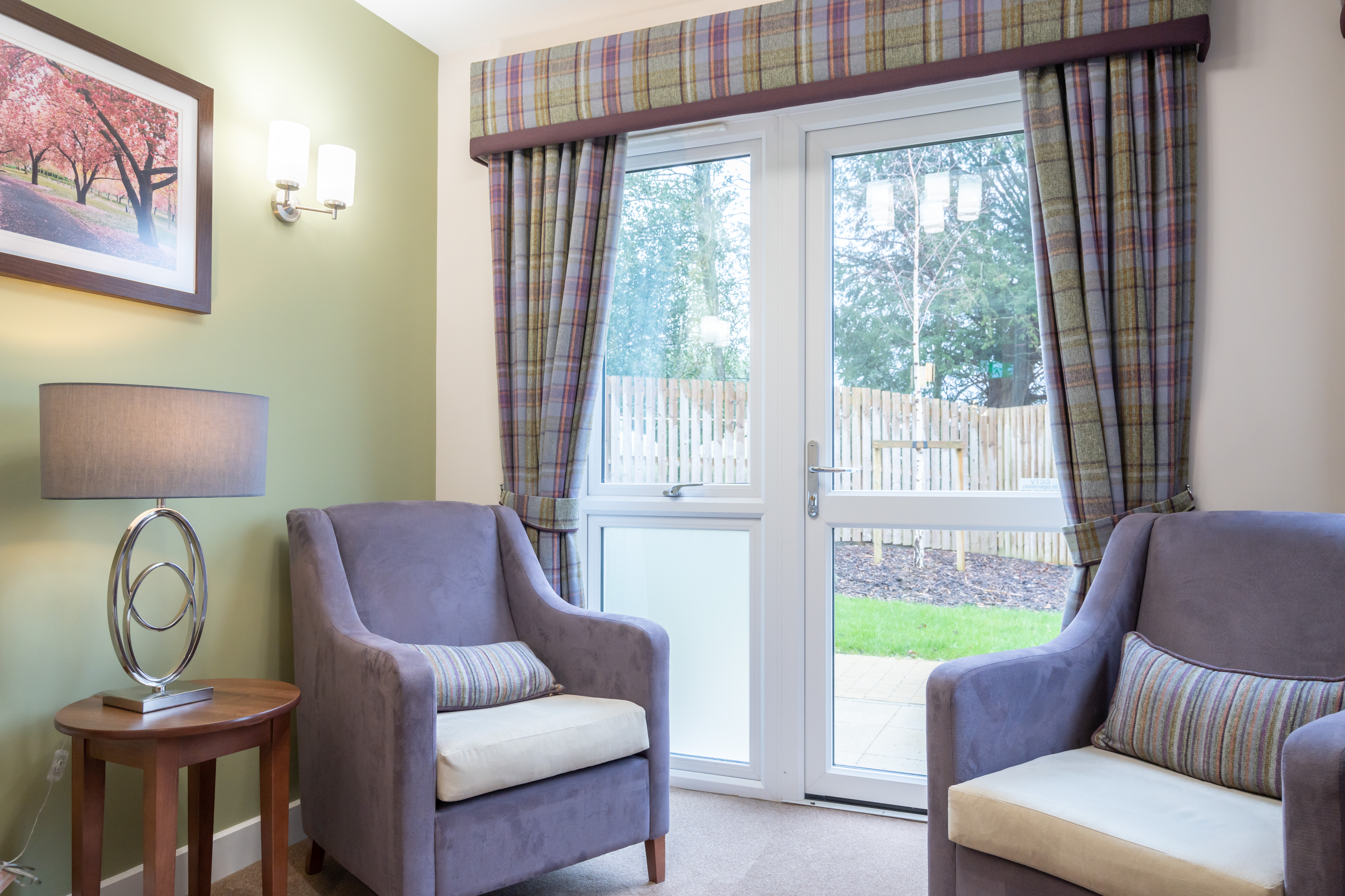 A cosy sitting area at Westall House with comfortable armchairs and a garden view