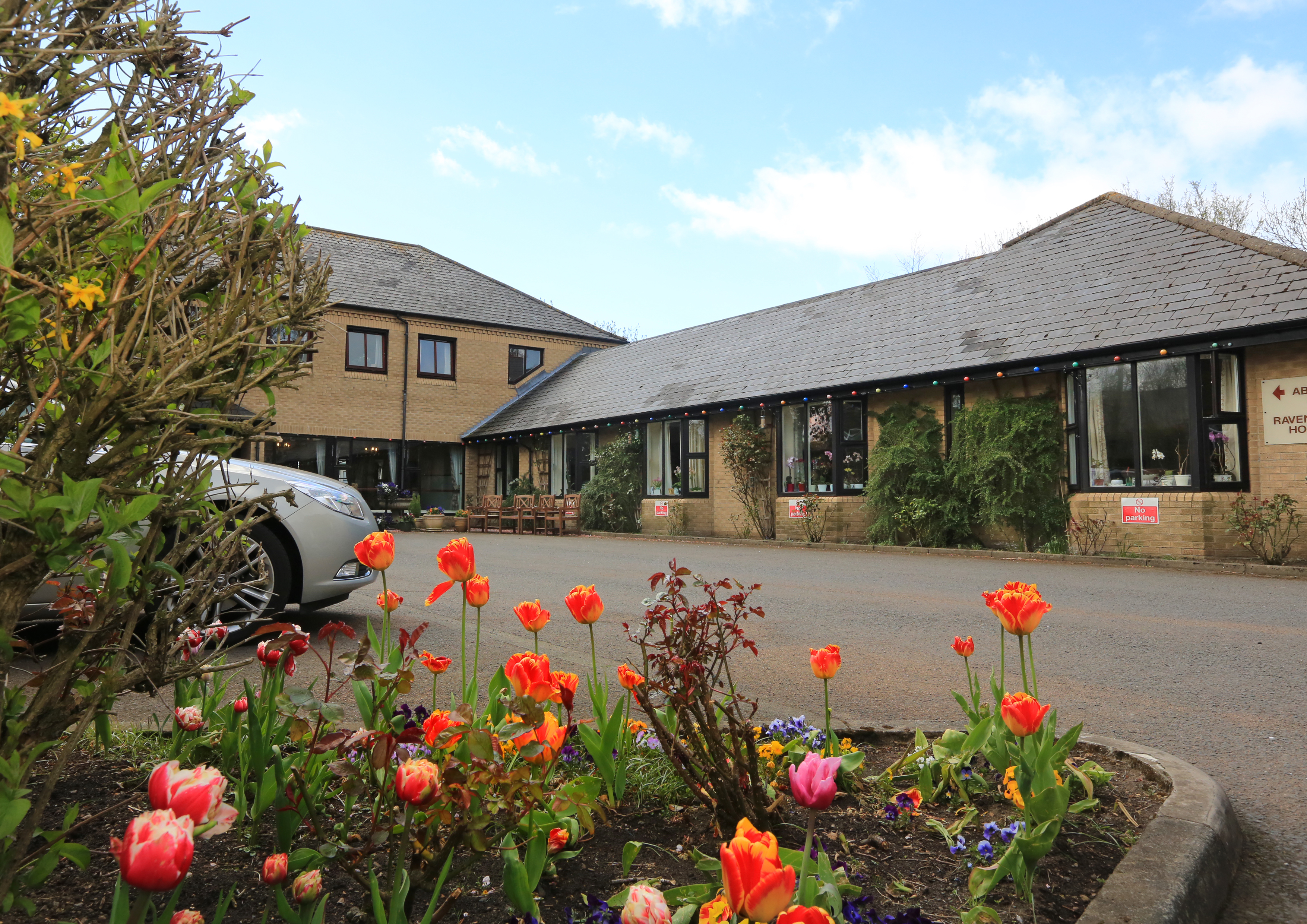 Abbeyfield House set behind a colourful flower bed