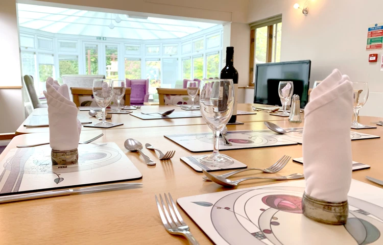 Beautifully set dining room table overlooking the conservatory at Garrad House