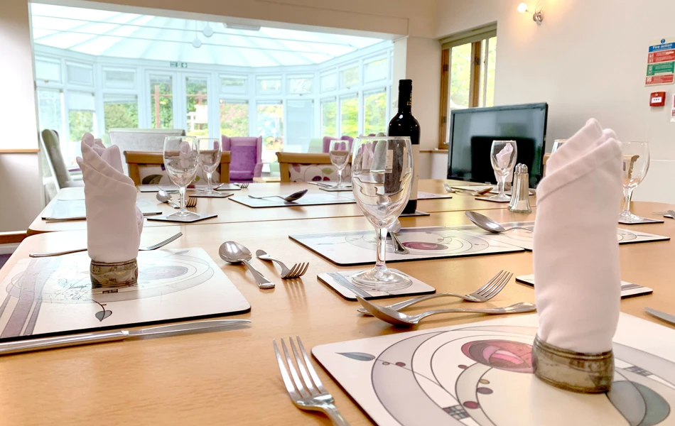 Beautifully set dining room table overlooking the conservatory at Garrad House