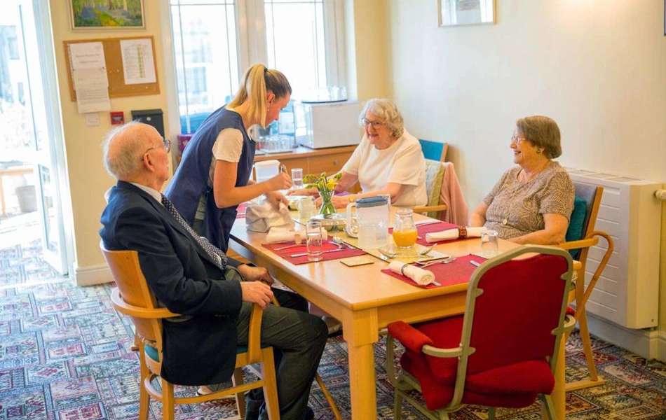 Residents sitting around the table waiting for their meal at Abbeyfield House